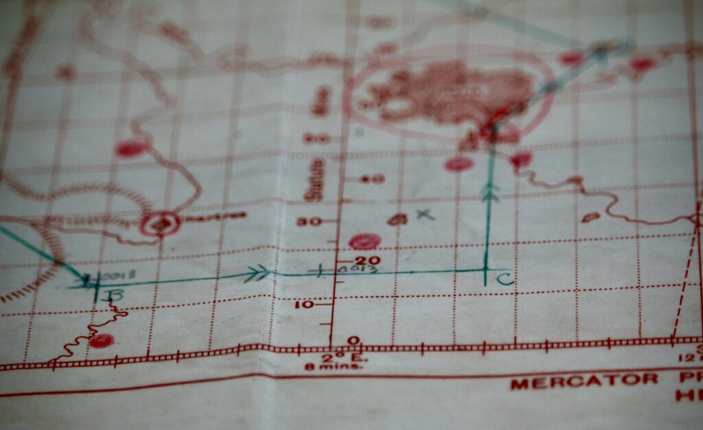 Detailed close-up of a vintage nautical map with visible coordinates and navigation markings.