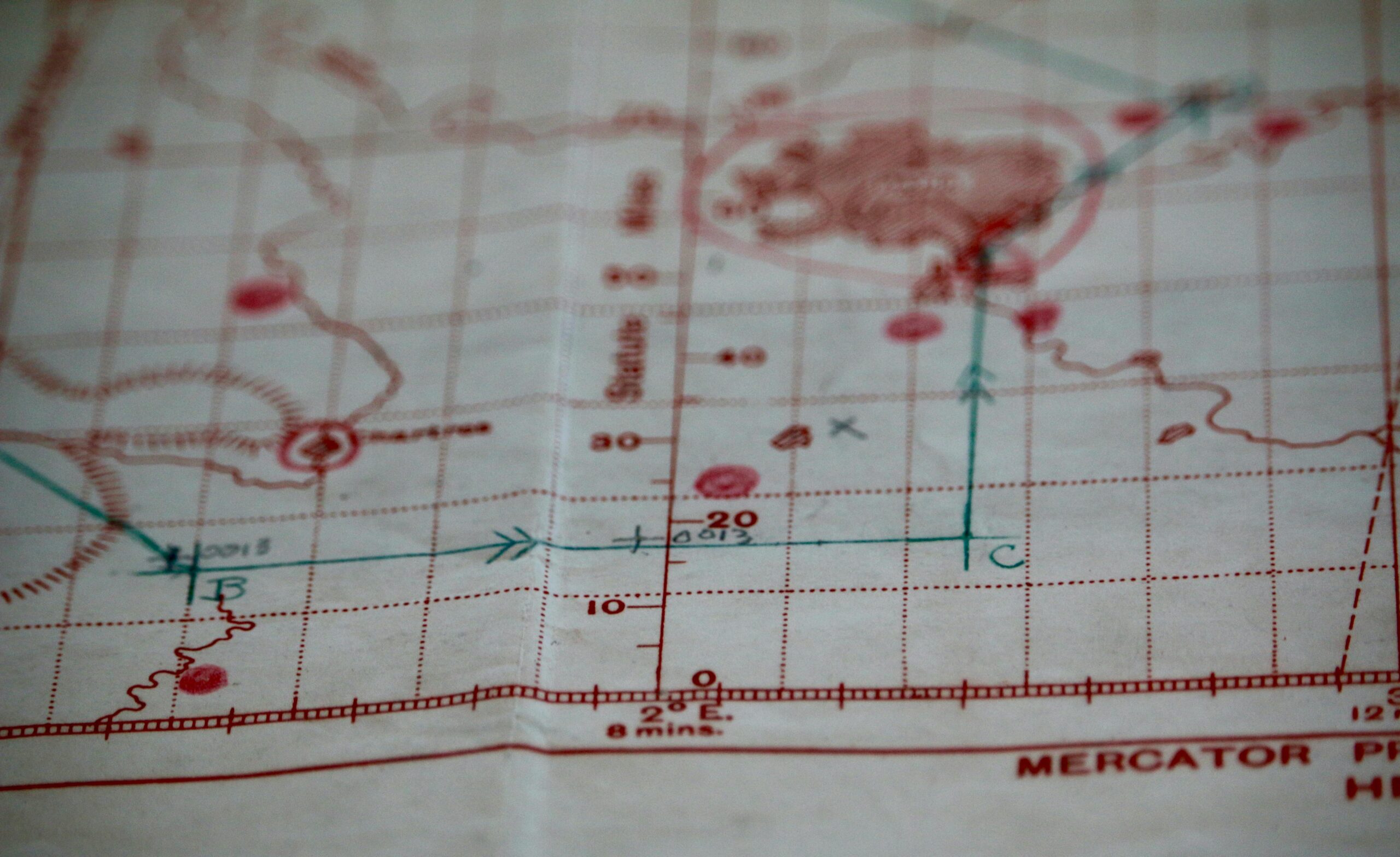 Detailed close-up of a vintage nautical map with visible coordinates and navigation markings.